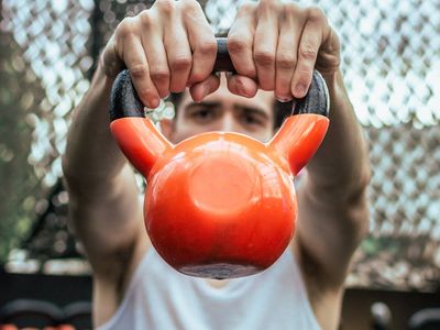 A person holding a heavy kettlebell during a training session