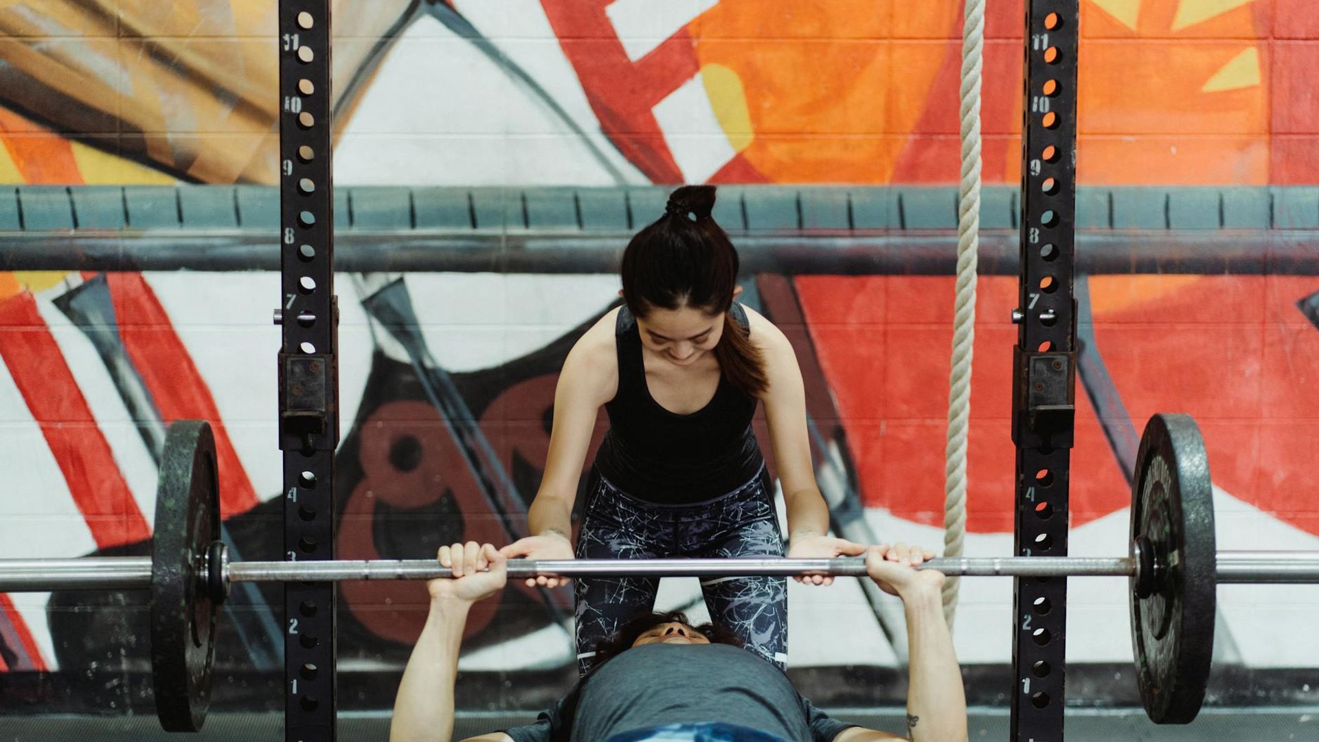 Athletic man performing strength exercise in a modern gym setup
